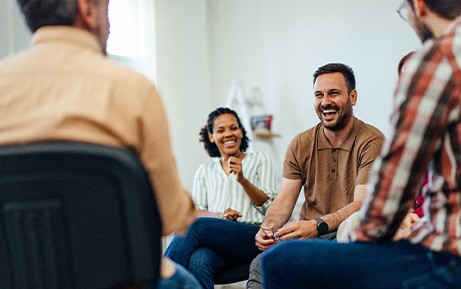 Four people in chairs talking and laughing