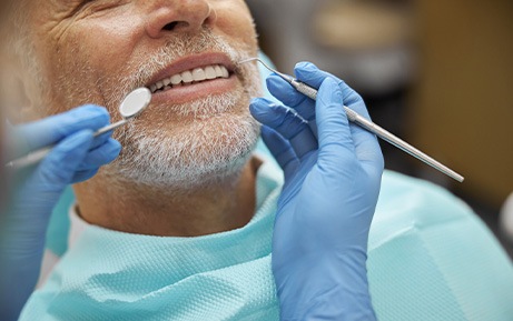 Man with white beard about to undergo dental exam