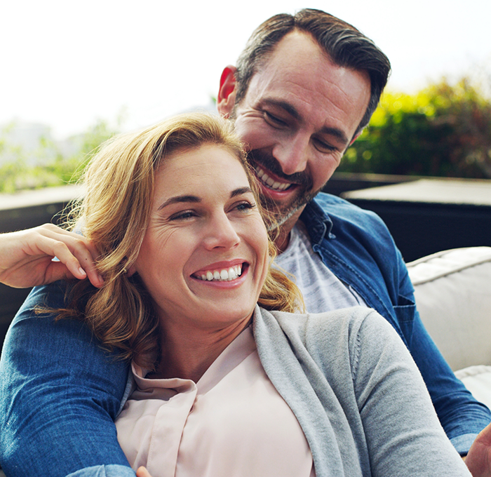 Man and woman sitting on porch and smiling after cosmetic dentistry in Clearwater