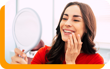 Dental patient admiring her smile in a mirror