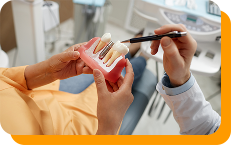 Dentist showing a model of a dental implant to a patient
