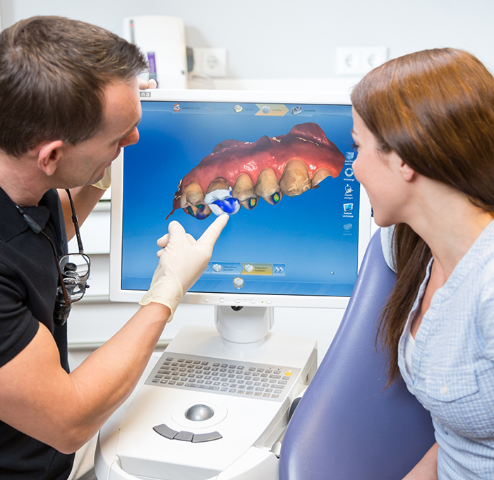 Dentist showing a patient a screen with a digital impression of their teeth