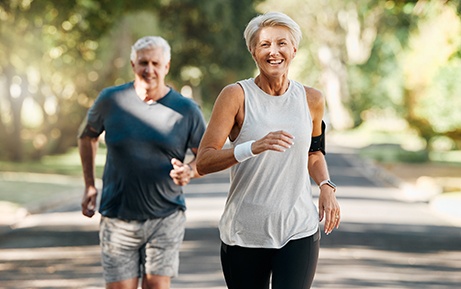 Senior couple running outside