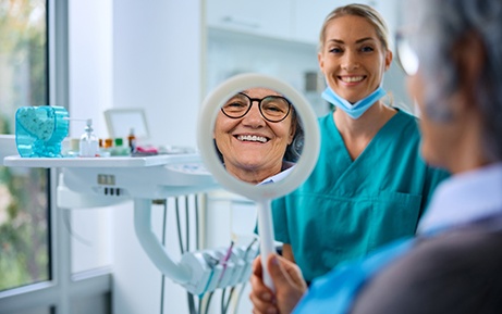 Patient with glasses smiling at reflection in mirror