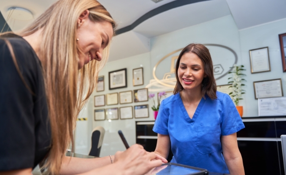 Two women looking at a tablet screen in a dental office