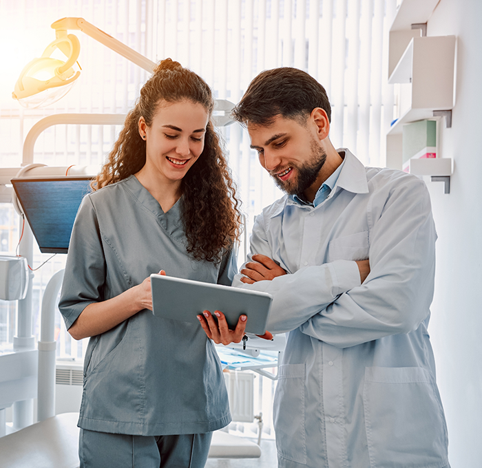 Two Clearwater dental team members looking at a tablet screen