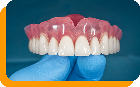 Gloved hand holding a full upper denture