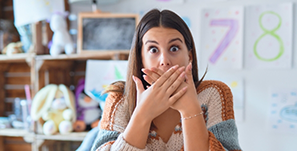 Woman looking surprised and covering her mouth with her hands