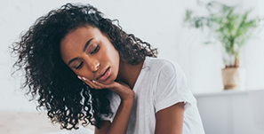 Woman wincing and holding her cheek in pain