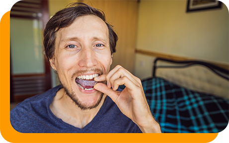 Man placing a nightguard over his teeth