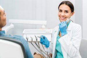 Dentist smiling and working on patient.
